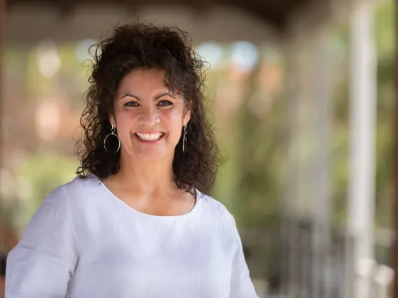 Laura Teso smiling for photo, wearing white blouse