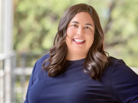 Mary Venezia smiling for photo, wearing dark blue blouse