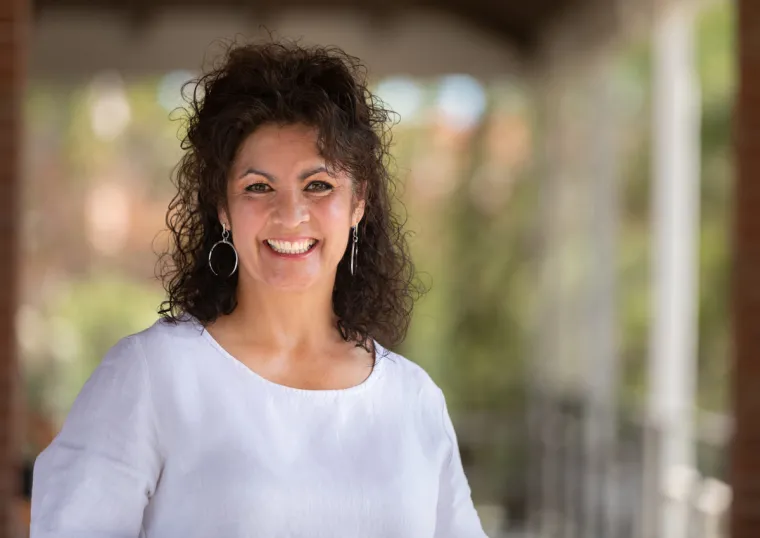 Laura Teso smiling for photo, wearing white blouse