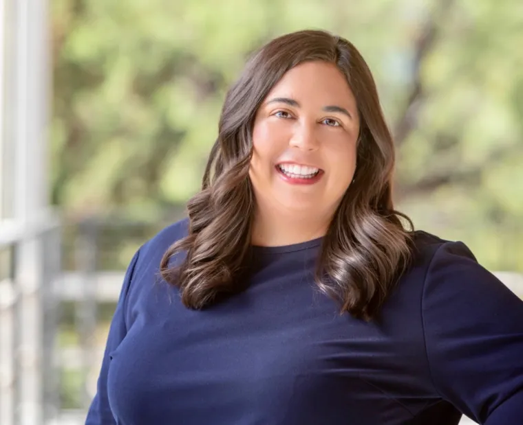 Mary Venezia smiling for photo, wearing dark blue blouse