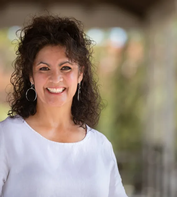 Laura Teso smiling for photo, wearing white blouse